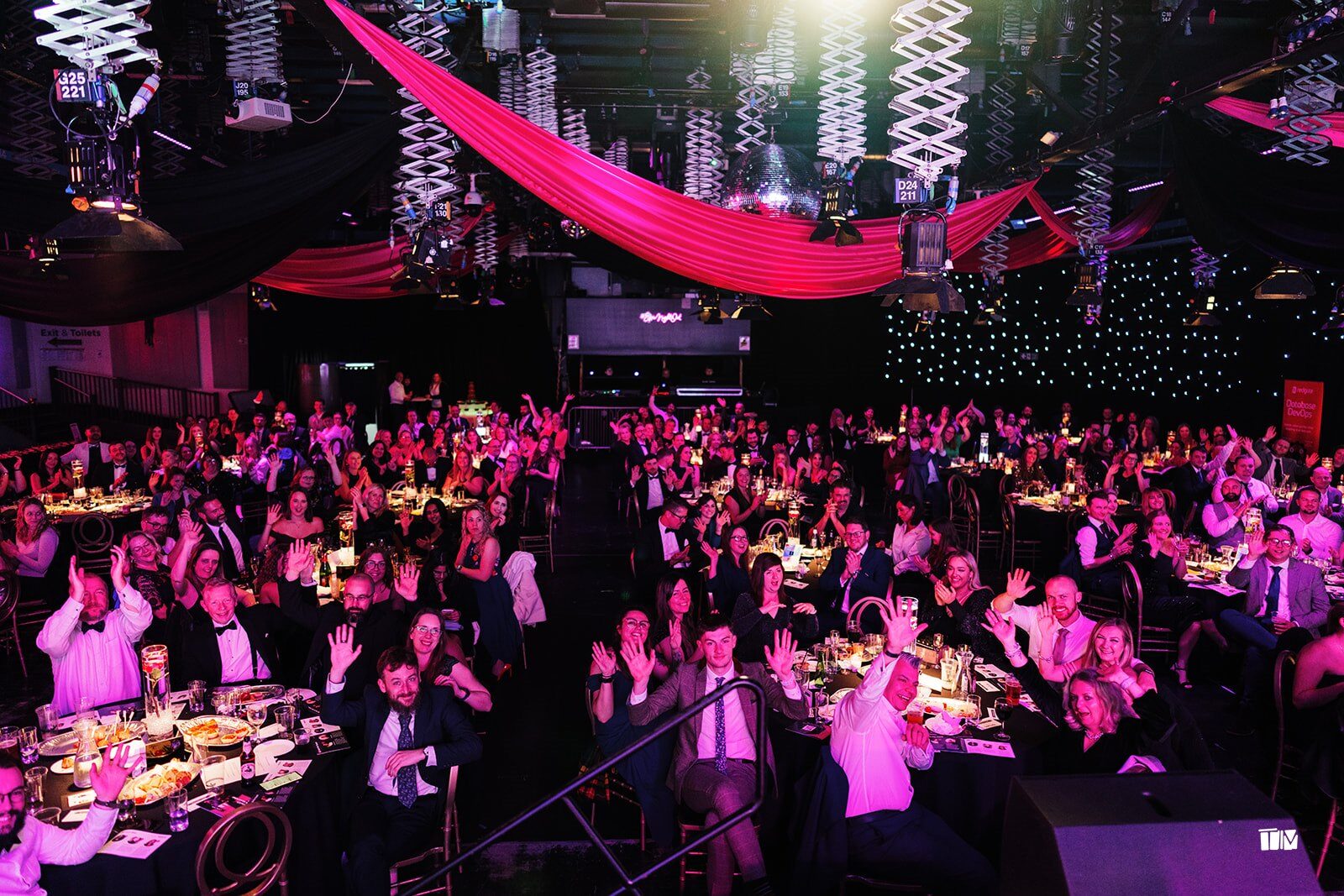Guests cheering at their tables during the DevelopHER Awards ceremony